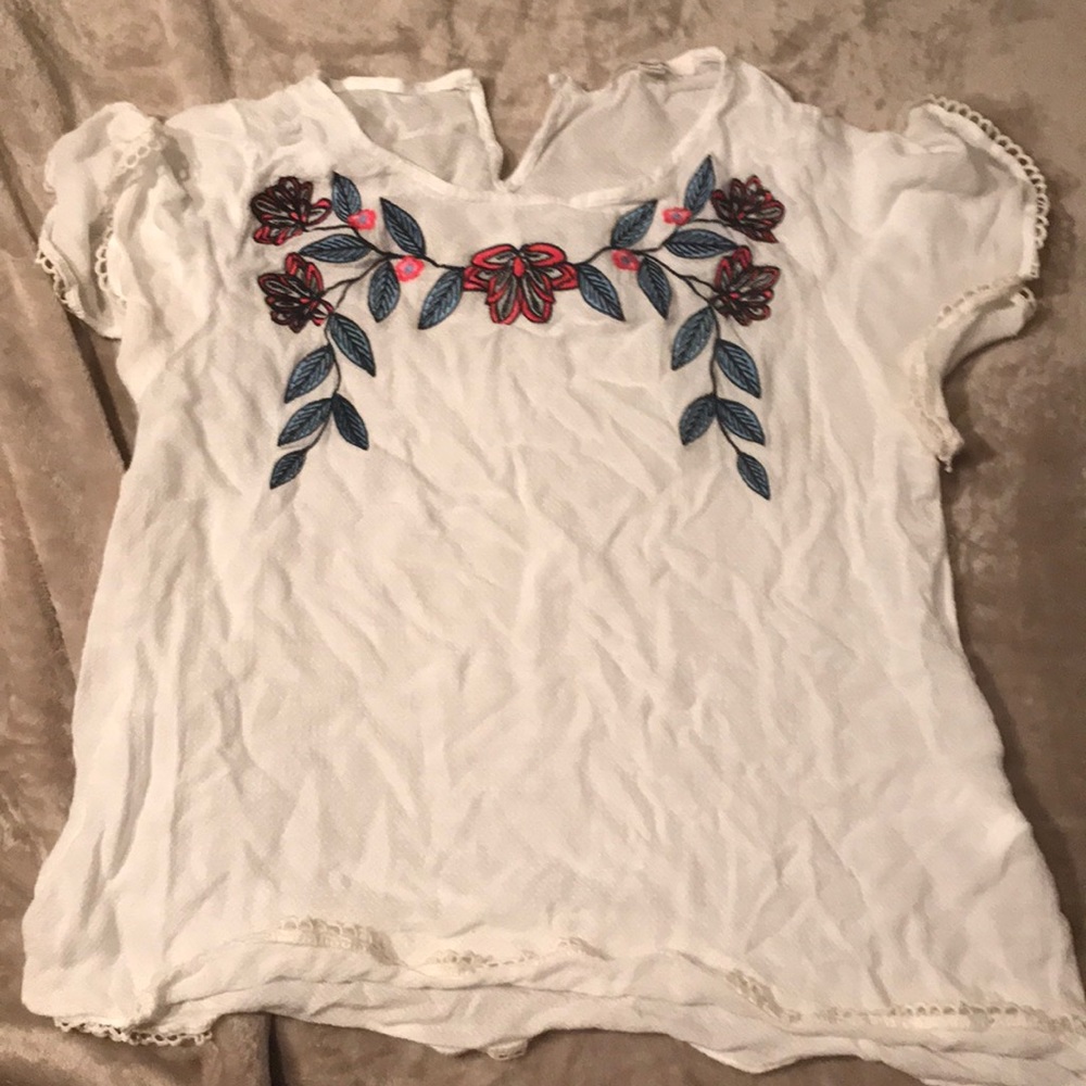 White top, flower embroidery and detailed sleeves.